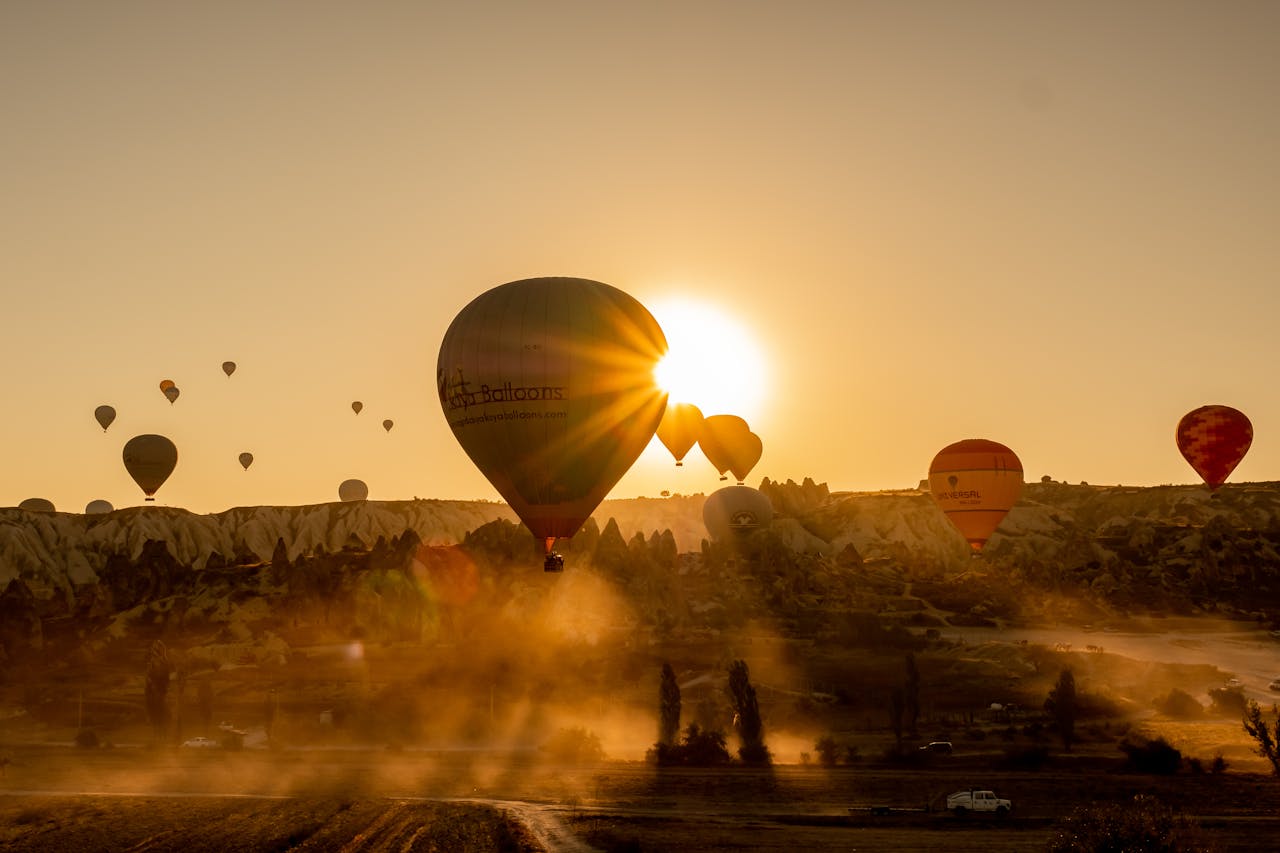 Hot air balloon rising with sunrise in Cappadocia valleys, Turkey | Conmigo Travel Agency